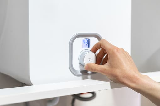 main qui règle un chauffe eau électrique